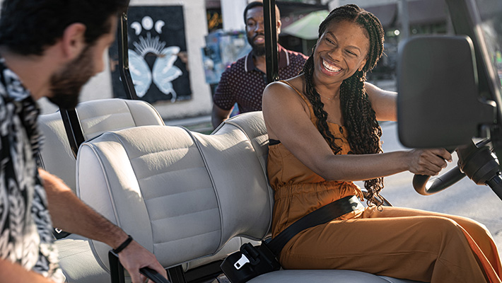 Smiling woman driving E-Z-GO vehicle 