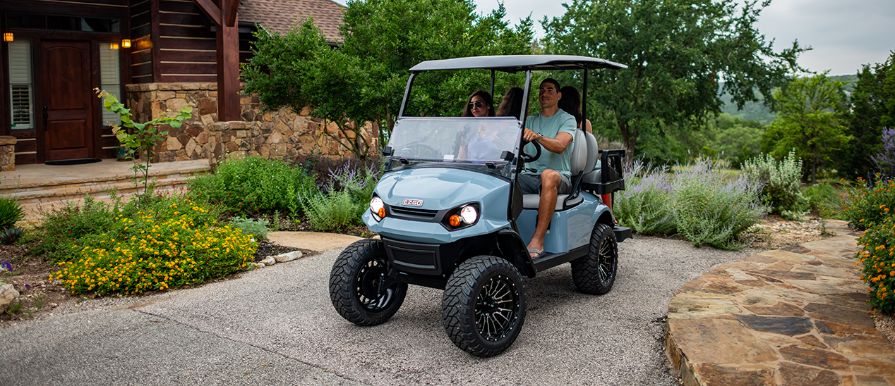 E-Z-GO Express S4 vehicle, a family of four preparing for a drive.