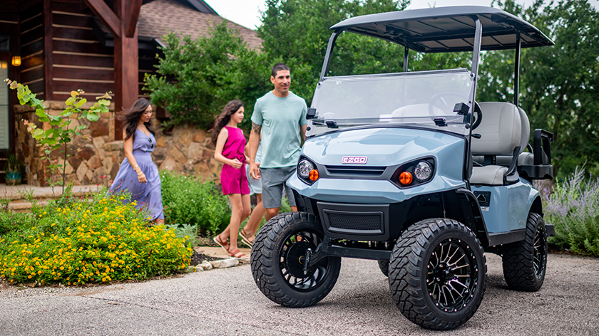 Family walking to E-Z-GO vehicle in driveway