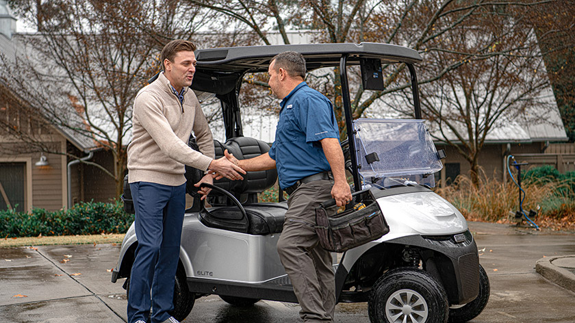 A customer greeting an E-Z-GO service technician.