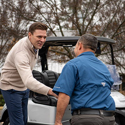 A technician greeting an E-Z-GO owner.