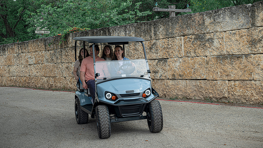 Customers driving an E-Z-GO Liberty in a neighborhood
