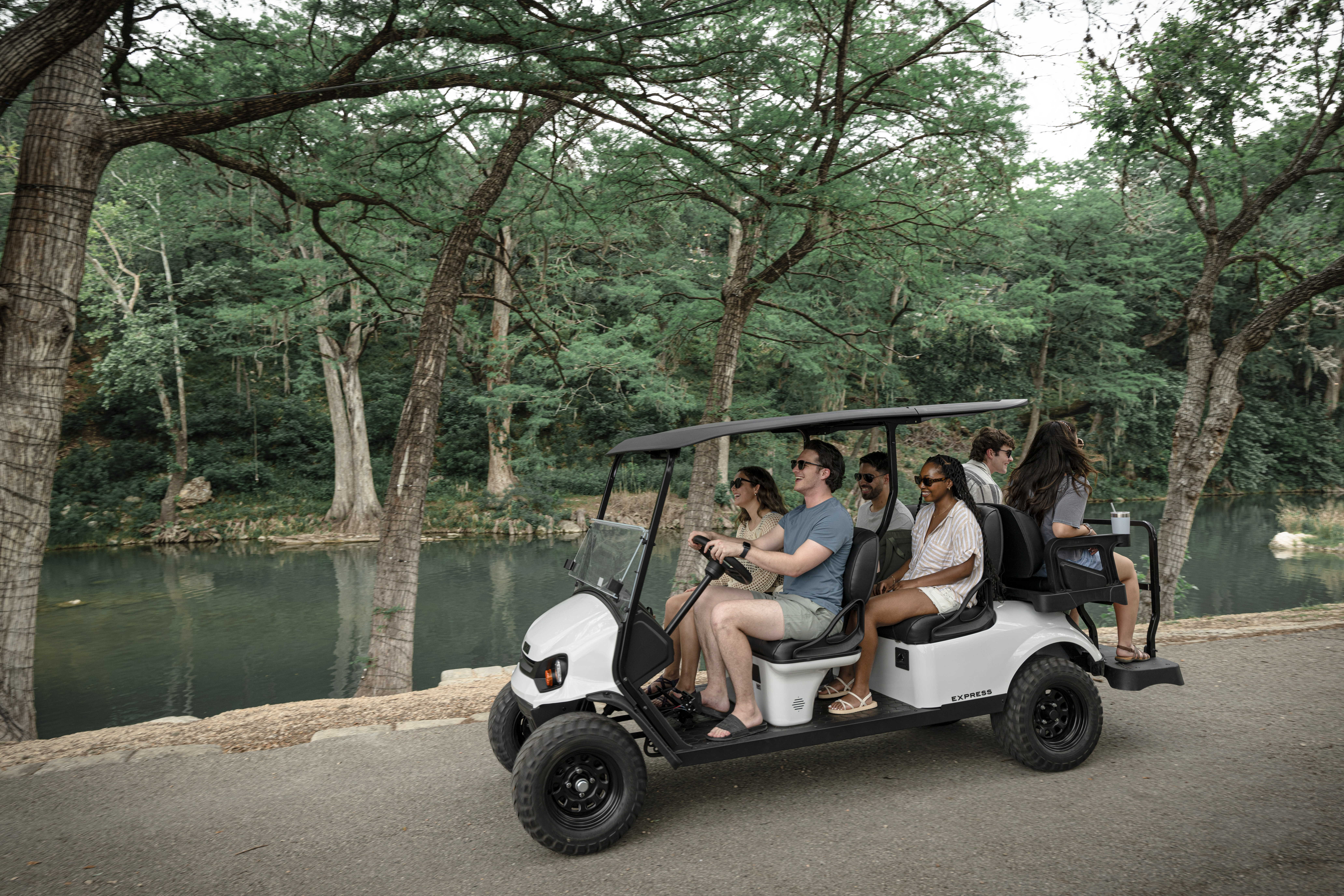 Group of 6 friends riding in an Express 6 by the river.