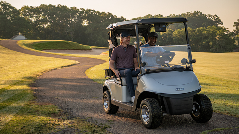 Two golfers on a cart path riding an RXV ELiTE.