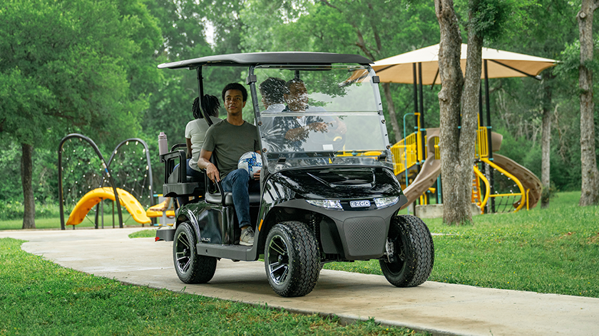 E-Z-GO Valor 4 driving on a sidewalk in a park