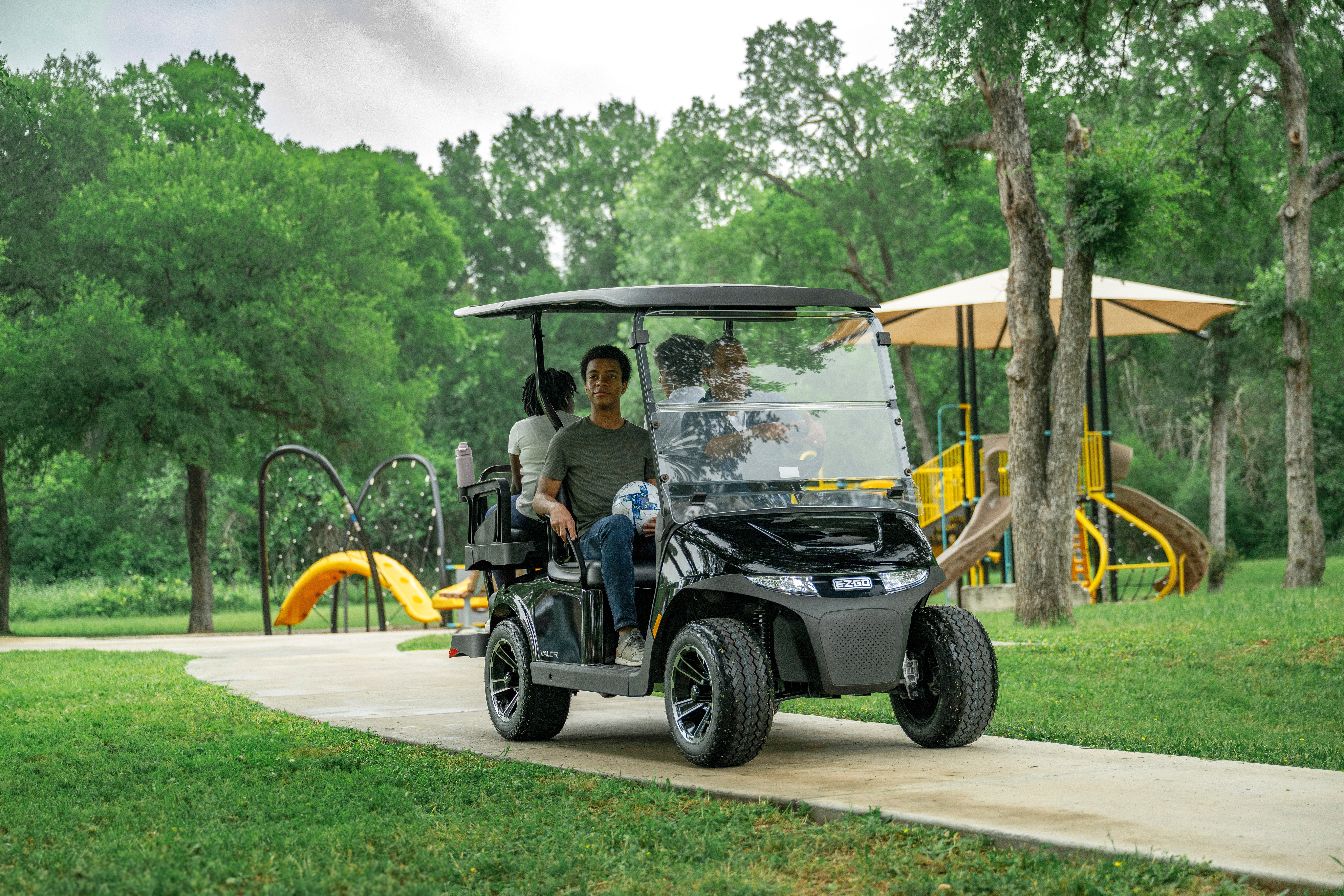 E-Z-GO Valor 4 driving on a sidewalk in a park