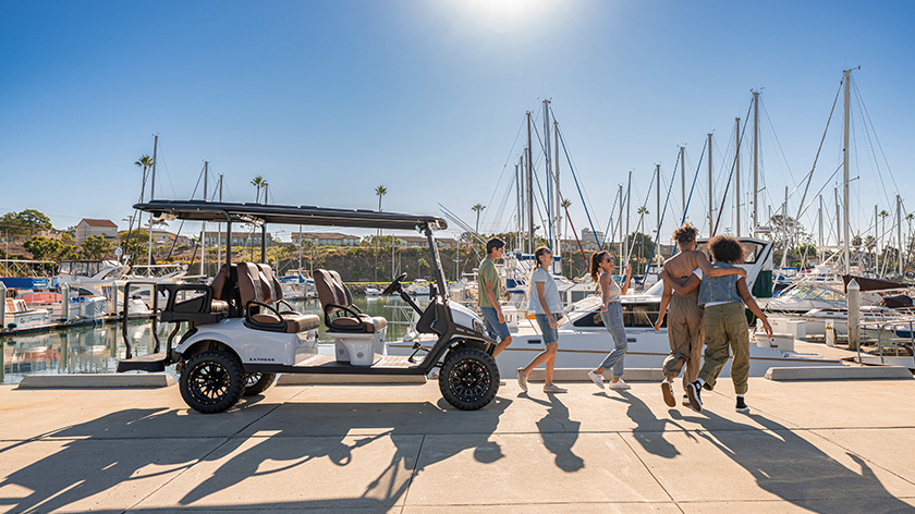 Group of friends getting off an Express 6 with LED Headlights with boats in the marina/harbor in the background