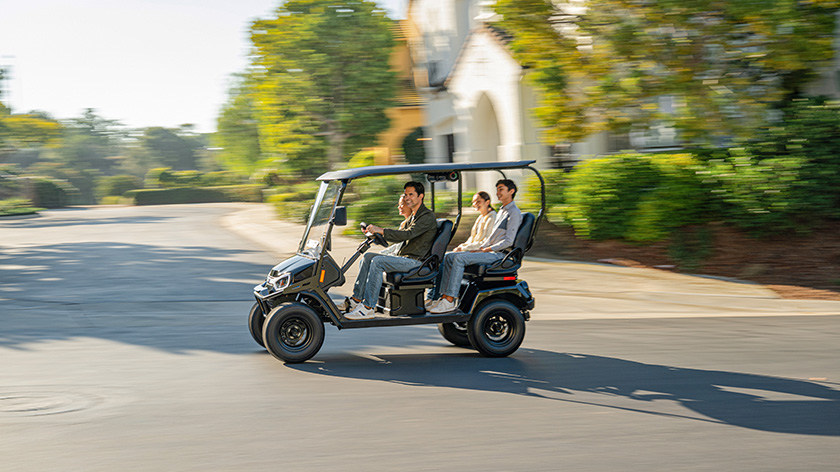 Liberty LSV driving in a neighborhood with a family 4 riding in the golf cart