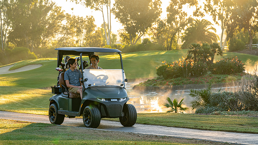Freedom RXV with father and son driving on a cart path through a golf course