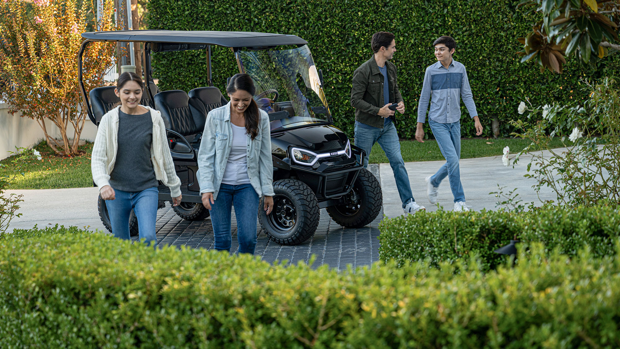 Liberty LSV in a driveway with a family of 4 walking towards a house