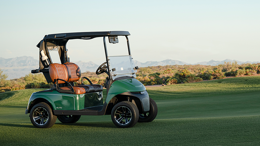 E-Z-GO golf cart sitting on a golf course with cactuses and mountains in the background
