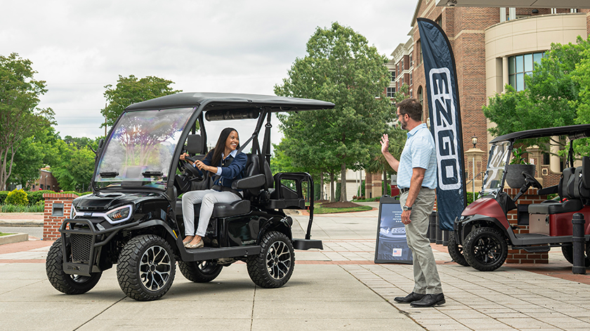 E-Z-GO Liberty 4 with 2 forward, 2 backward seats electric or gas golf cart leaving a golf cart dealership