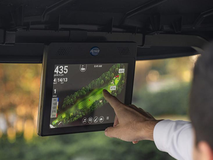 A hand interacting with E-Z-GO Pace Technology in their golf cart.
